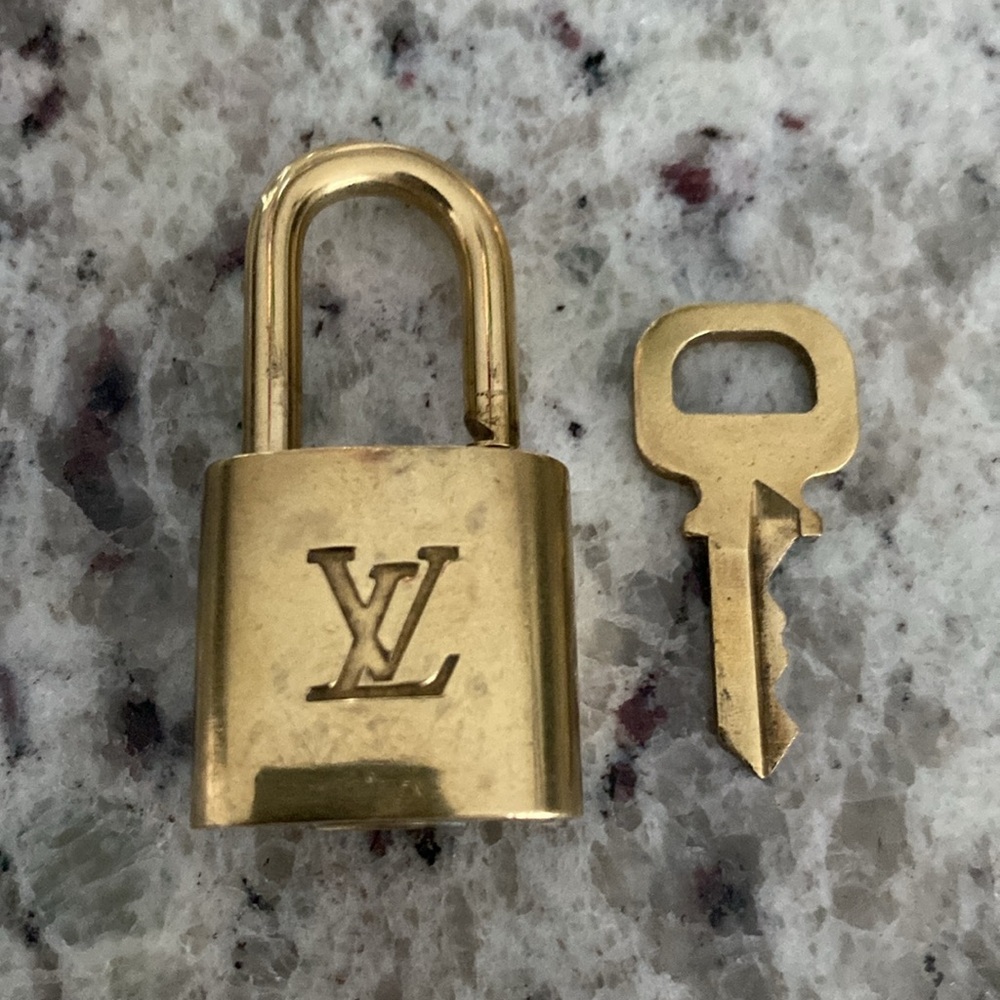 Authentic Louis Vuitton Padlock & Key Set # 323. Preowned in great condition.